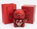A red teddy bear with a rose inside